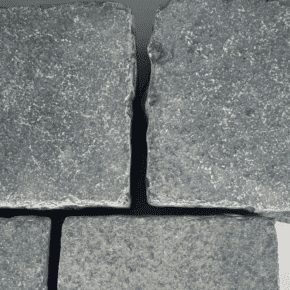 Close-up of black tumbled limestone setts with natural texture and finish