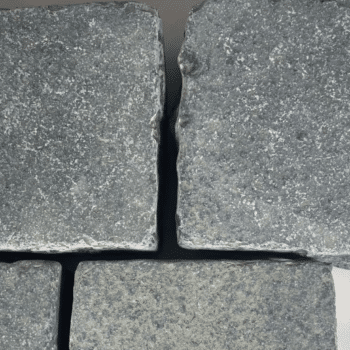 Close-up of black tumbled limestone setts with natural texture and finish