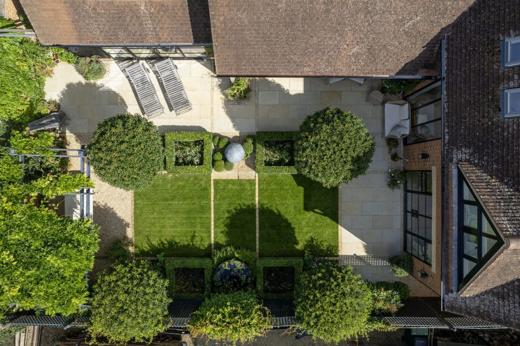 Aerial view of the rear courtyard garden, with La Roche limestone paving framing a lawn, clipped box squares and standard trees