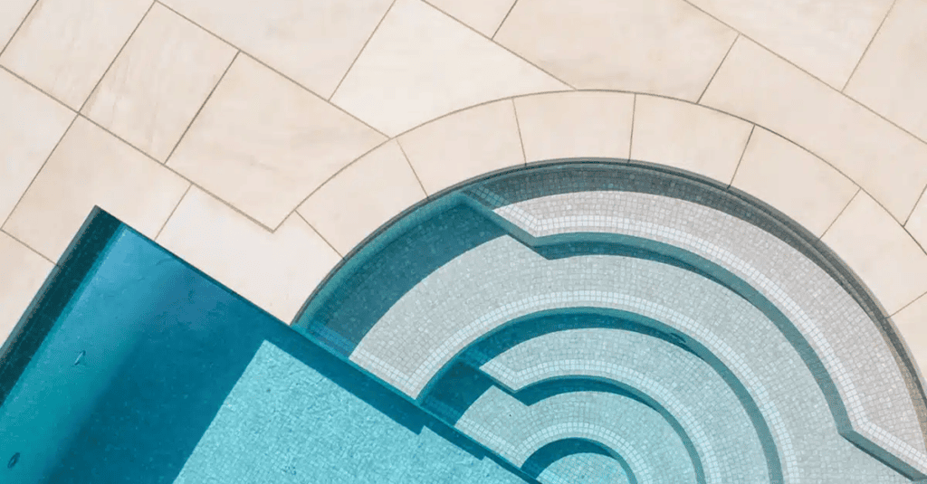 White Mint honed sandstone pool copings around a pool with roman end steps